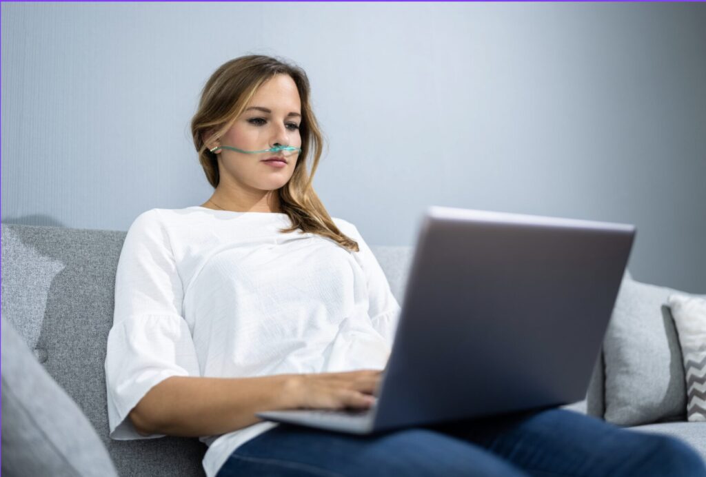 a woman sitting on a sofa with a hydrogen therapy tube on her face. 